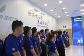 一群人站在蓝色壁报板前中度可信度描述已自动生成